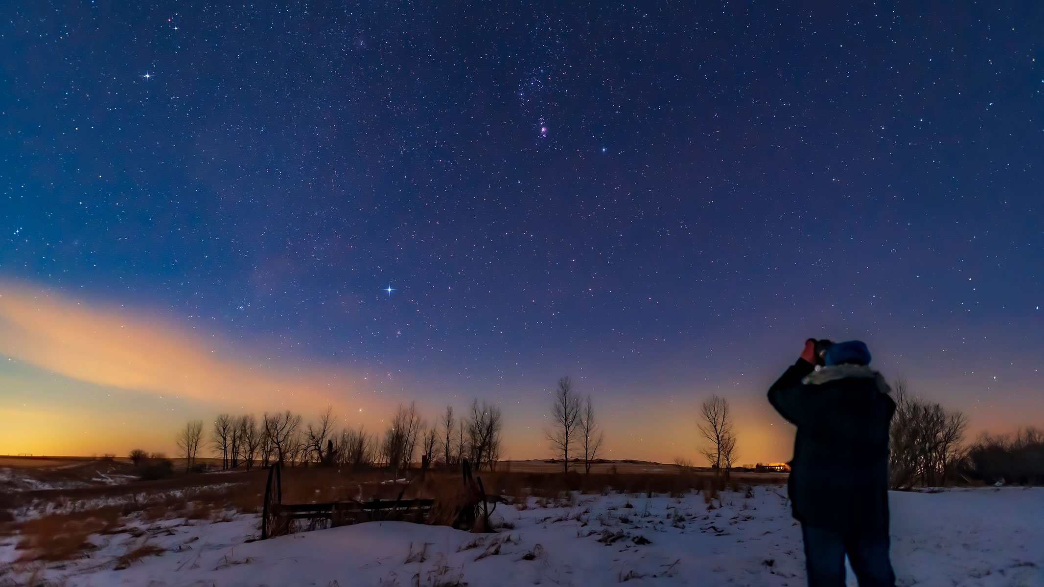 Person observing the night sky with binoculars