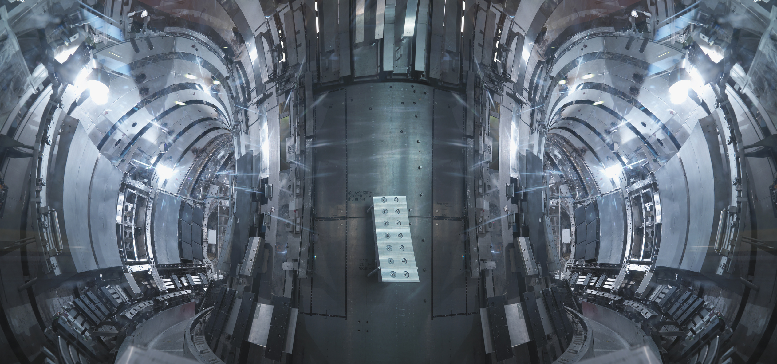 Bright lights illuminate the circular tunnel in the tokamak nuclear fusion reactor.