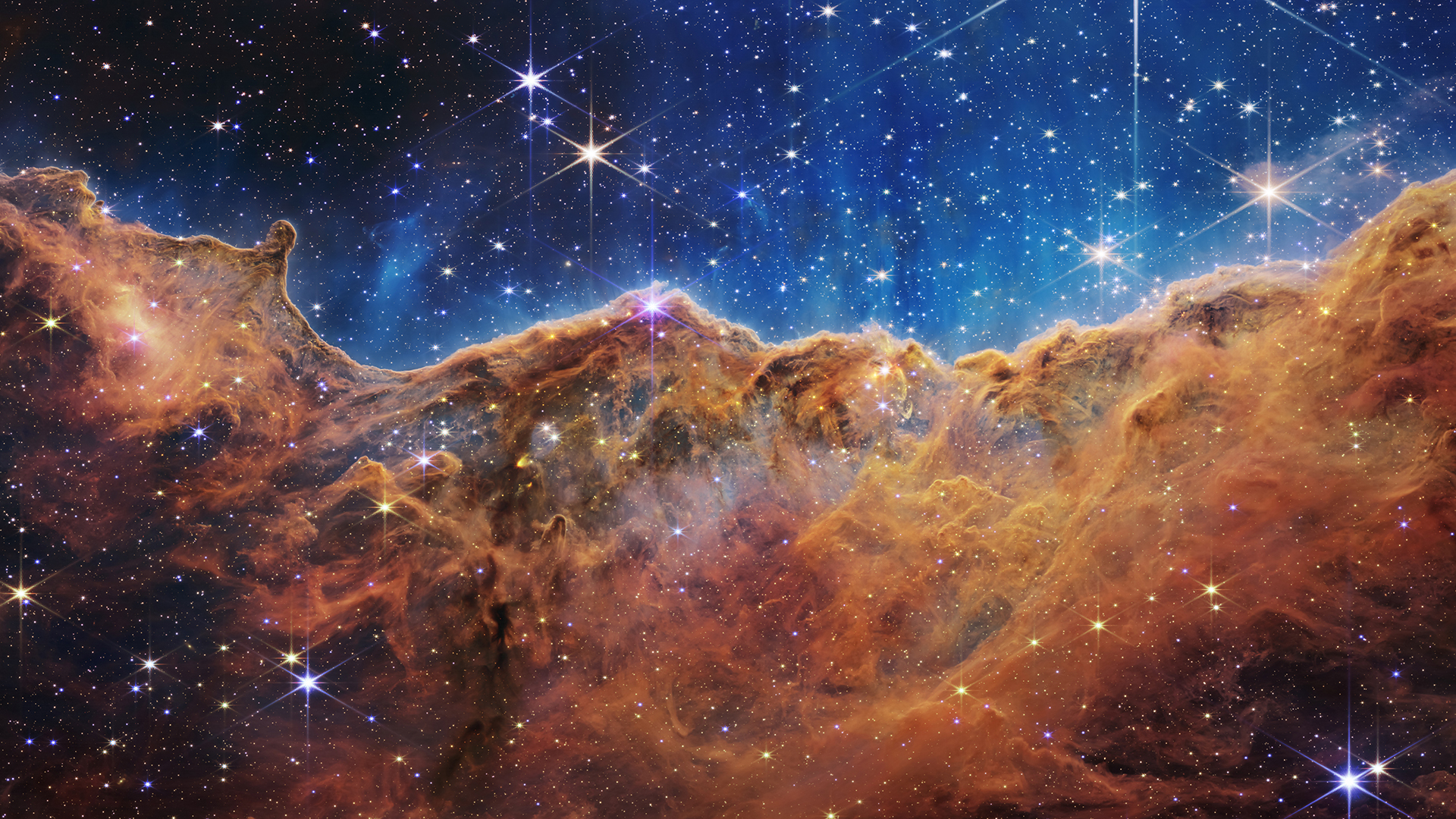 This landscape of "mountains" and "valleys" speckled with glittering stars is actually the edge of a nearby, young, star-forming region called NGC 3324 in the Carina Nebula. Captured in infrared light by NASA&amp;rsquo;s new James Webb Space Telescope, this image reveals for the first time previously invisible areas of star birth.