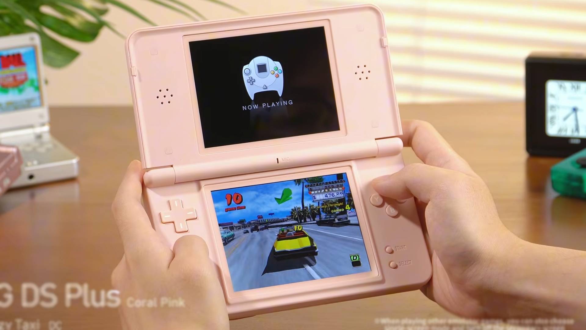 Anbernic RG DS Plus in pink with hands using handheld to play Crazy Taxi for Sega Dreamcast.