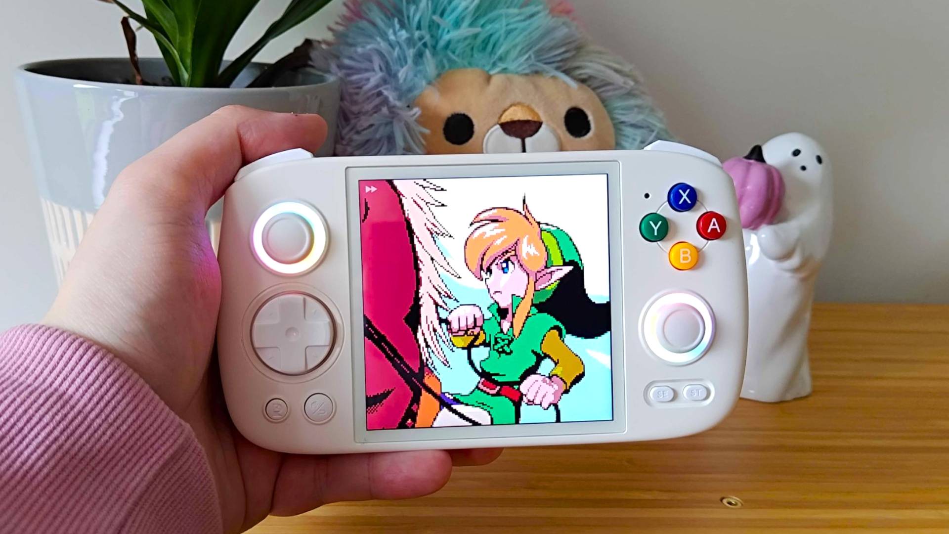 Hand holding Anbernic RG Cube with gameplay from Zelda: Oracle of Seasons intro on screen.