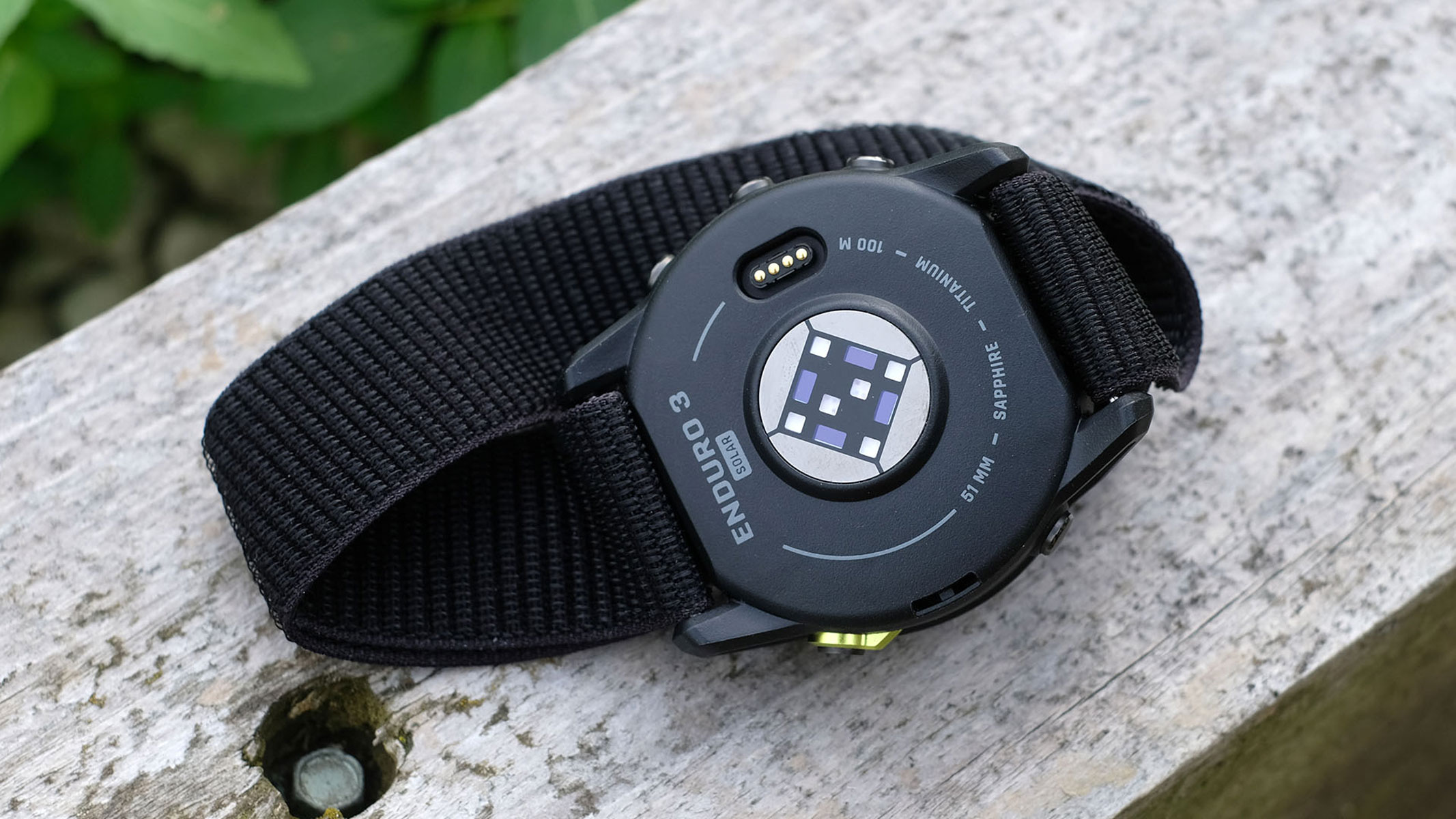A picture of the Garmin Enduro 3 smartwatch sitting on top of a wooden plank
