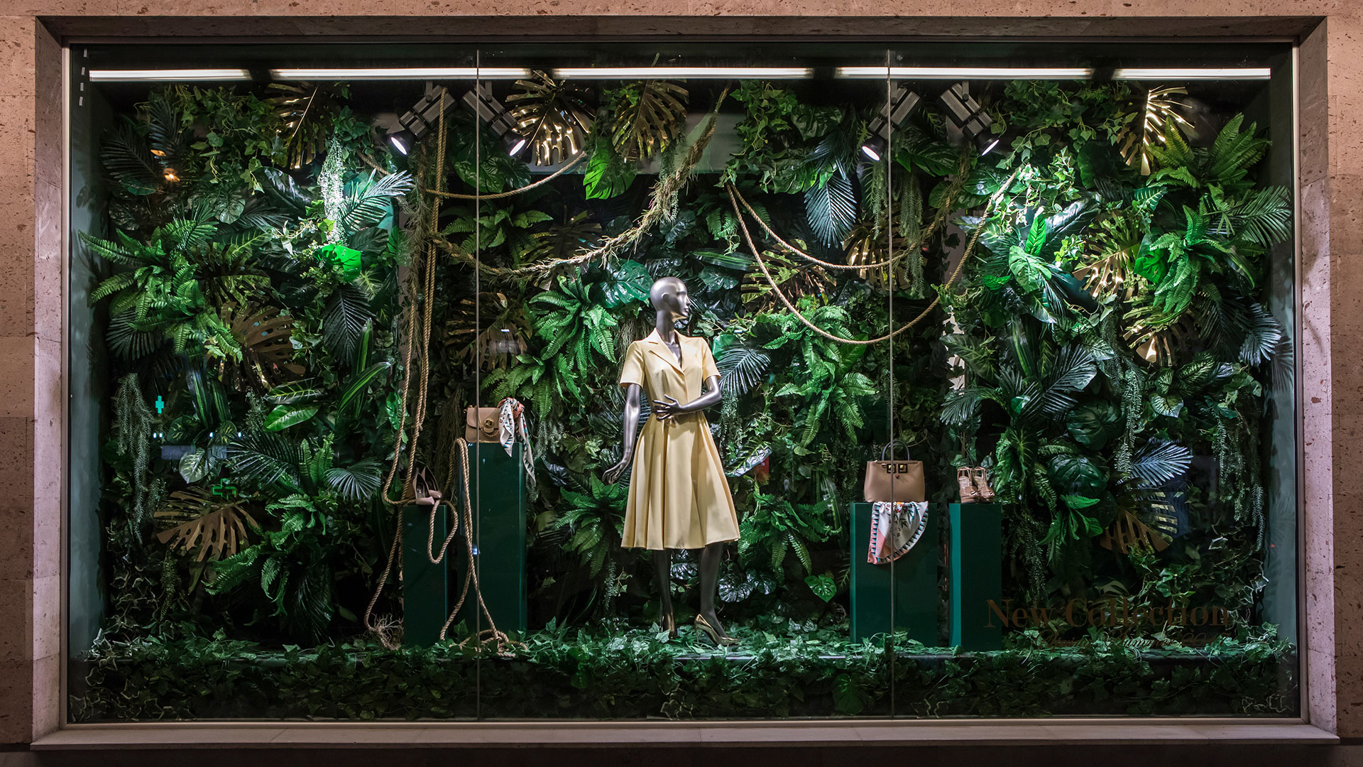 LaGalleria shop window with female mannequin in khaki dress in jungle