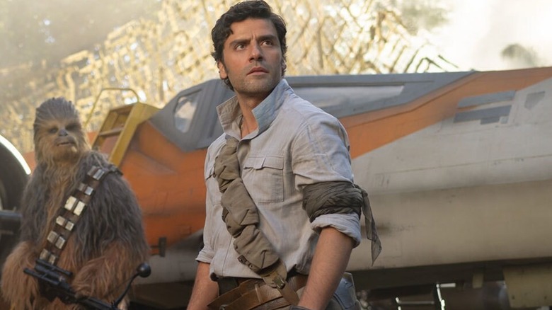 Chewbacca and Poe standing in front of an X-wing fighter